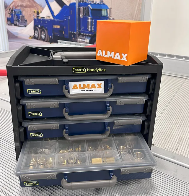 raaco handybokx med sortimentslåder. En orange kube med ALMAX står ovanpå